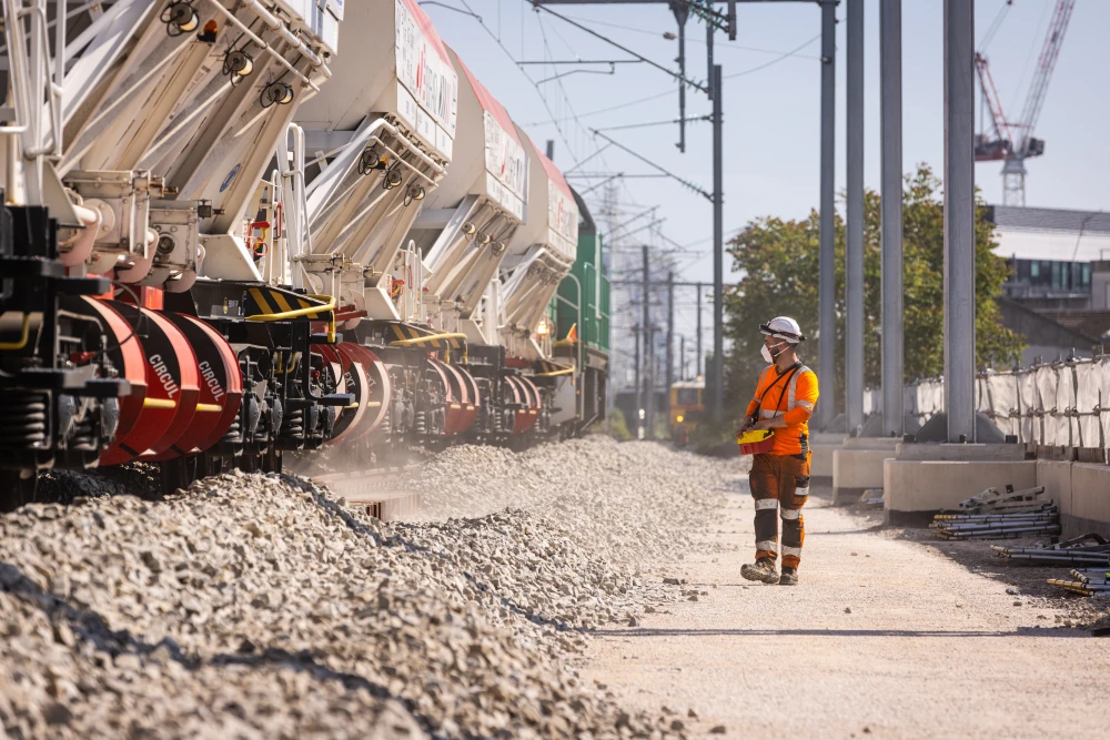 Les trains de services déposent le ballast le long des voies